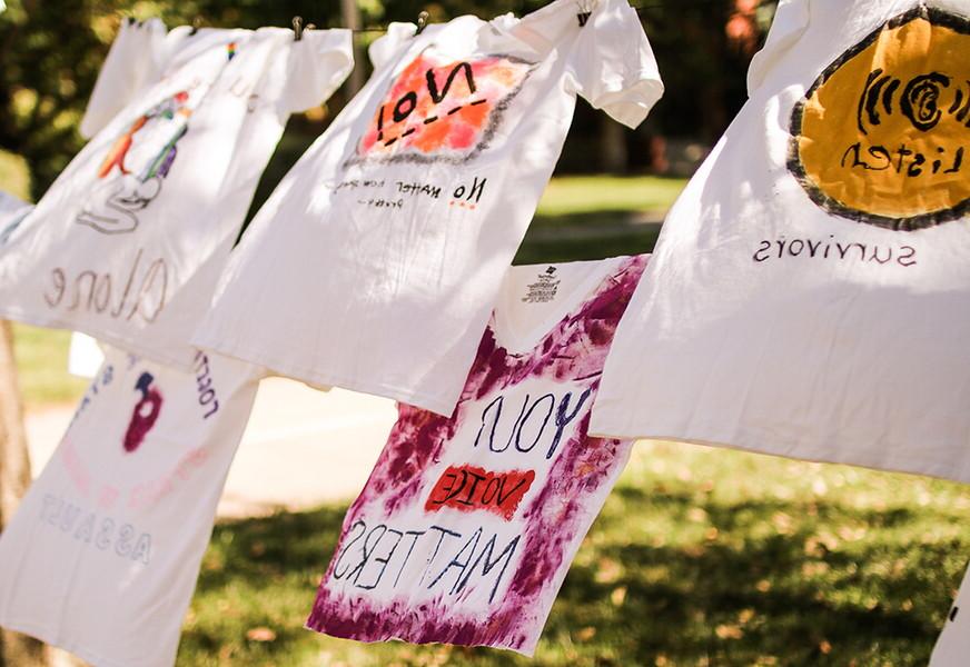 图书馆前的晾衣绳上挂着t恤，上面写着提高人们对性别暴力意识的信息